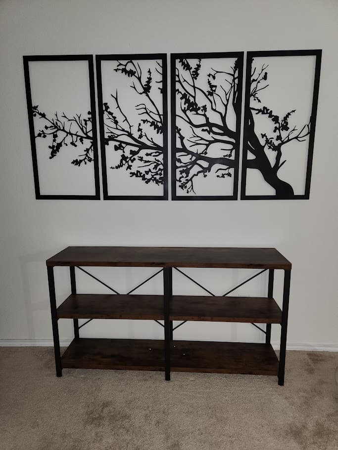 Four-panel tree wall art mounted above a console table