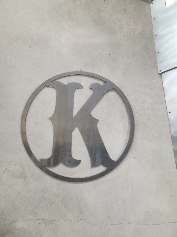 Circle K plasma cut metal sign laid out on a shop floor